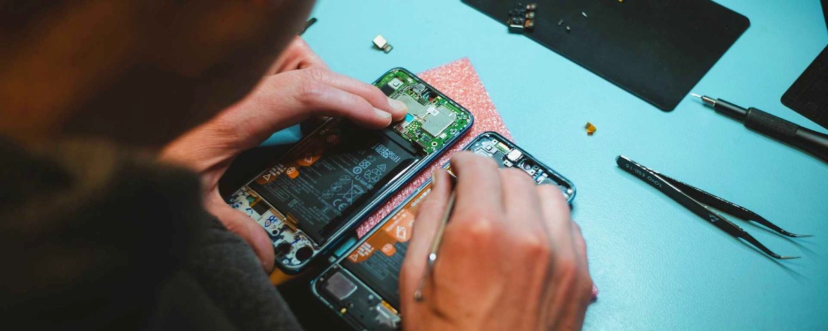 Artisan repérant un téléphone mobile démonté
